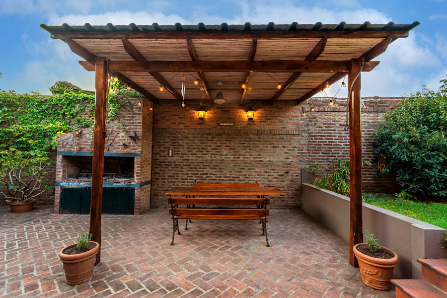 Timber pergola with string lights over a brick patio